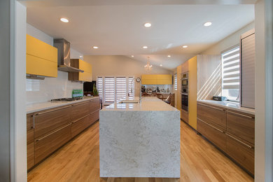Eat-in kitchen - mid-sized modern u-shaped laminate floor and brown floor eat-in kitchen idea in Los Angeles with a drop-in sink, flat-panel cabinets, brown cabinets, quartzite countertops, white backsplash, porcelain backsplash, stainless steel appliances, an island and white countertops