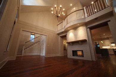 Inspiration for a mid-sized formal and enclosed medium tone wood floor and brown floor living room remodel in New Orleans with beige walls, a standard fireplace and no tv