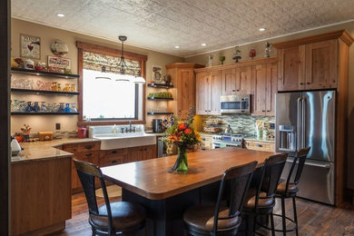 Example of a mid-sized arts and crafts u-shaped dark wood floor eat-in kitchen design in Other with a farmhouse sink, shaker cabinets, medium tone wood cabinets, granite countertops, beige backsplash, metal backsplash, stainless steel appliances and no island