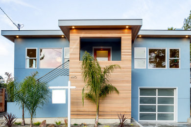 Imagen de fachada de casa azul moderna de dos plantas con revestimiento de madera y tejado plano