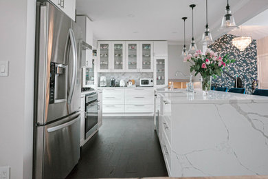 Inspiration for a mid-sized contemporary brown floor eat-in kitchen remodel in Detroit with a farmhouse sink, white cabinets, quartz countertops, multicolored backsplash, glass tile backsplash, stainless steel appliances, an island and white countertops