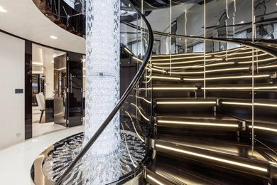 Example of a large transitional metal curved metal railing staircase design in Los Angeles with metal risers