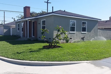 Large elegant gray one-story stucco exterior home photo in Los Angeles
