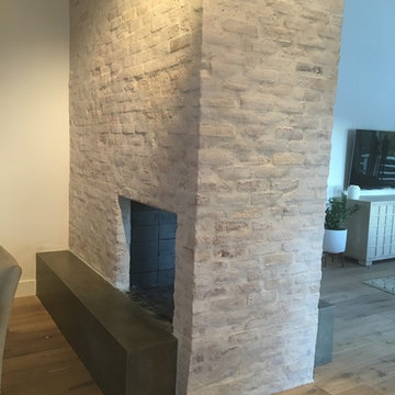 Concrete hearth white washed brick fireplace surround