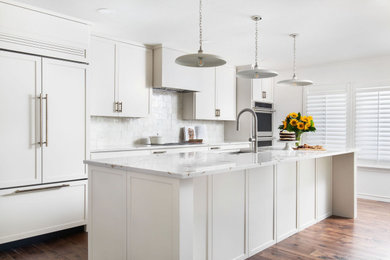 Inspiration for a mid-sized transitional kitchen remodel in Austin with shaker cabinets, white cabinets, beige backsplash, stainless steel appliances, an island and beige countertops