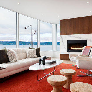 Exempel på ett modernt vardagsrum, med vita väggar, mellanmörkt trägolv, en standard öppen spis och brunt golv