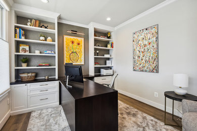 Home office - mid-sized transitional built-in desk medium tone wood floor home office idea in DC Metro with gray walls and no fireplace