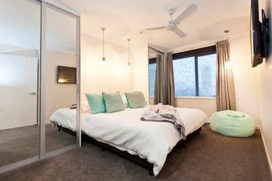 This is an example of a contemporary master bedroom in Brisbane with white walls.