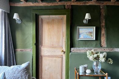 Imagen de salón de estilo de casa de campo pequeño con paredes verdes, suelo de madera oscura, marco de chimenea de ladrillo, pared multimedia y suelo marrón