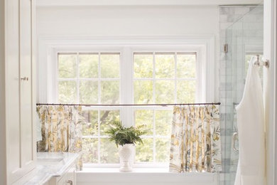 Example of a classic master stone tile bathroom design in Other with raised-panel cabinets and marble countertops