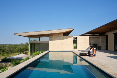Идея дизайна: прямоугольный бассейн среднего размера на заднем дворе в стиле модернизм с покрытием из каменной брусчатки