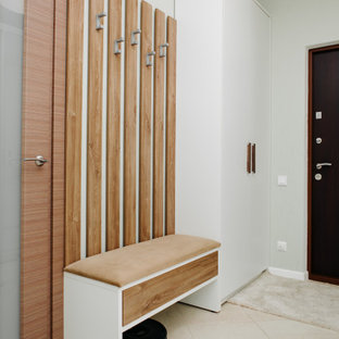 Modern inredning av en liten hall, med gröna väggar, klinkergolv i keramik, en enkeldörr, metalldörr och beiget golv