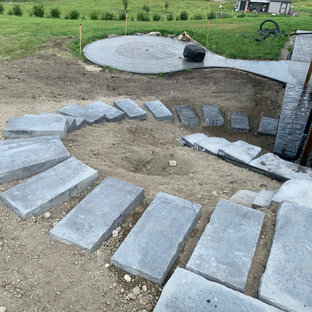 Immagine di una piccola scala curva chic con pedata in cemento, alzata in cemento, parapetto in materiali misti e pareti in mattoni