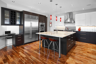 Eat-in kitchen - large contemporary u-shaped medium tone wood floor and brown floor eat-in kitchen idea in Edmonton with an undermount sink, flat-panel cabinets, dark wood cabinets, granite countertops, white backsplash, glass tile backsplash, stainless steel appliances, an island and multicolored countertops