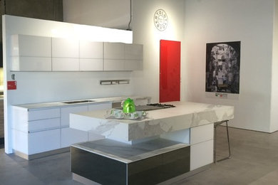 Inspiration for a small contemporary galley concrete floor eat-in kitchen remodel in Other with glass-front cabinets, white cabinets, white backsplash and an island