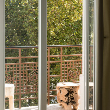 Interior View to Balcony with Wood Stool and Tree Canopy