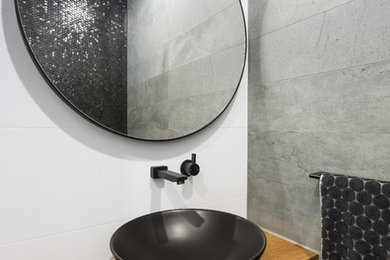 Photo of a mid-sized contemporary master bathroom in Sydney with open cabinets, medium wood cabinets, porcelain tile, white walls, porcelain floors, a vessel sink, laminate benchtops and grey floor.