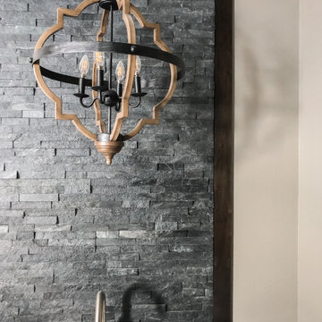 Chandelier over master soaking tub with stone wall
