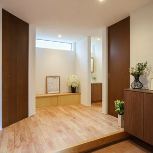 Immagine di un corridoio moderno di medie dimensioni con pareti bianche, pavimento in gres porcellanato, una porta scorrevole, una porta in legno bruno e pavimento arancione