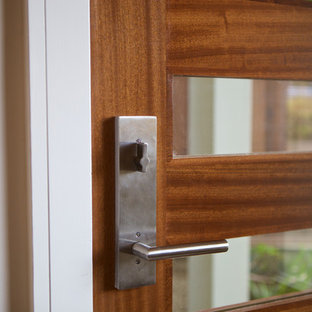 Exemple d'une grande porte d'entrée éclectique avec un mur blanc, un sol en carrelage de céramique, une porte simple, une porte en bois brun et un sol bleu.