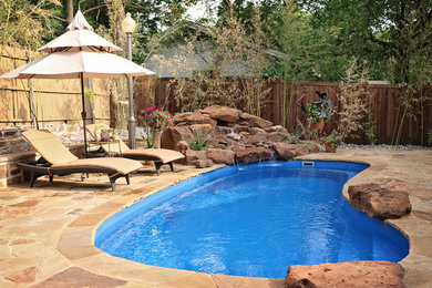 Mid-sized traditional backyard kidney-shaped natural pool in Dallas with a water feature and natural stone pavers.