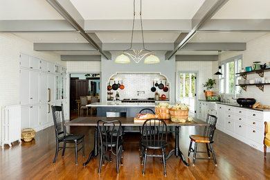 Photo of a large country kitchen/dining combo in Portland with white walls, dark hardwood floors and no fireplace.