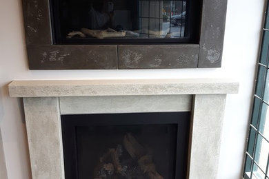 Example of a transitional living room design in Vancouver with a concrete fireplace