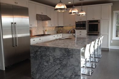 Mid-sized transitional l-shaped medium tone wood floor and gray floor eat-in kitchen photo in Other with an undermount sink, shaker cabinets, white cabinets, marble countertops, gray backsplash, mosaic tile backsplash, stainless steel appliances and an island