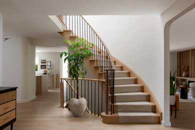 Inspiration for a contemporary wooden curved metal railing staircase remodel in Toronto with wooden risers