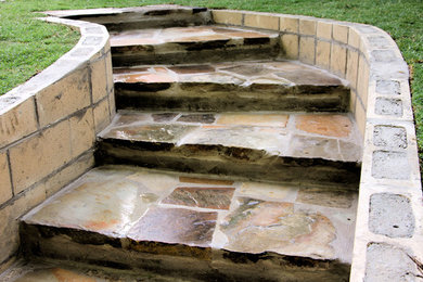 Inspiration for a mid-sized rustic partial sun backyard stone retaining wall landscape in Dallas.