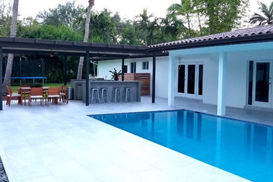 Design ideas for a mid-sized contemporary backyard rectangular lap pool in Miami with concrete pavers.