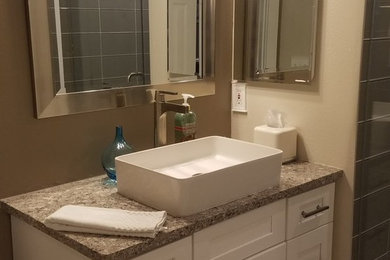 Photo of a small traditional shower room bathroom in Tampa with shaker cabinets, white cabinets, a corner shower, grey tiles, ceramic tiles, beige walls, vinyl flooring, a vessel sink, granite worktops, grey floors, a hinged door and beige worktops.