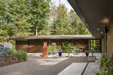 Mid-sized trendy one-story wood house exterior photo in Portland with a shed roof, a metal roof and a gray roof