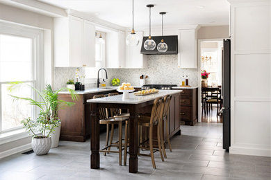 Transitional u-shaped gray floor eat-in kitchen photo in Philadelphia with an undermount sink, shaker cabinets, white cabinets, quartz countertops, black appliances, an island and multicolored countertops