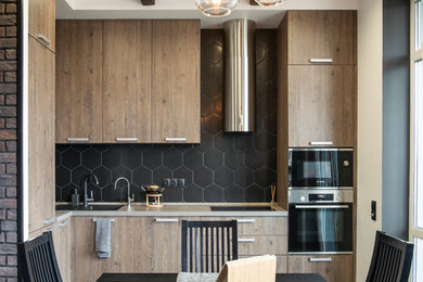 Photo of a contemporary eat-in kitchen in Moscow with an undermount sink, flat-panel cabinets, medium wood cabinets, black splashback, stainless steel appliances, medium hardwood floors, no island, brown floor and beige benchtop.