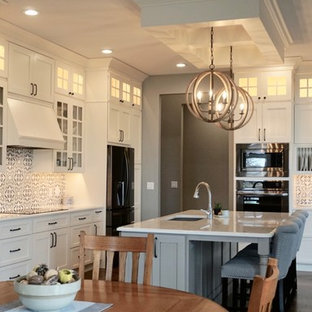 Large transitional kitchen pantry ideas - Kitchen pantry - large transitional l-shaped medium tone wood floor kitchen pantry idea in Cedar Rapids with an undermount sink, shaker cabinets, white cabinets, quartz countertops, multicolored backsplash, cement tile backsplash, stainless steel appliances and an island