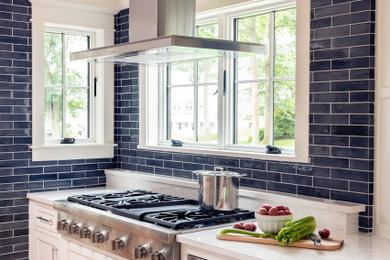 Example of a mid-sized classic medium tone wood floor eat-in kitchen design in Boston with beaded inset cabinets, white cabinets, granite countertops, blue backsplash, subway tile backsplash and stainless steel appliances