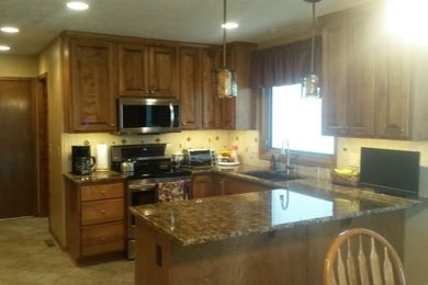 Eat-in kitchen - mid-sized traditional u-shaped beige floor eat-in kitchen idea in Omaha with a double-bowl sink, raised-panel cabinets, medium tone wood cabinets, white backsplash, stainless steel appliances and no island