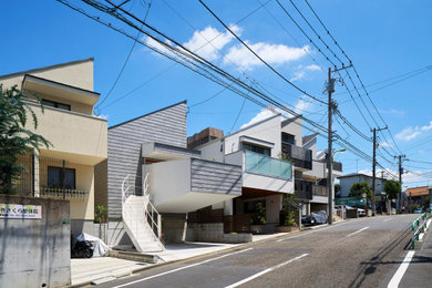 Mid-sized minimalist gray two-story mixed siding and clapboard house exterior photo in Tokyo with a shed roof, a metal roof and a gray roof
