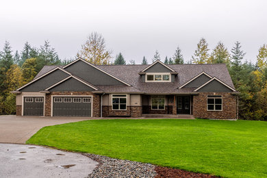 Large arts and crafts multicolored two-story mixed siding house exterior photo in Seattle with a hip roof and a shingle roof