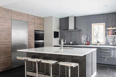 Photo of a contemporary l-shaped kitchen in Orange County with an undermount sink, flat-panel cabinets, grey cabinets, grey splashback, stainless steel appliances, with island, grey floor and white benchtop.