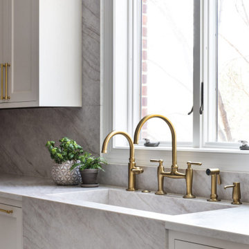 Custom Walnut and White Kitchen Remodel with Marble Slab Backsplash and Brass Ac