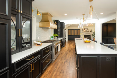 Eat-in kitchen - large galley medium tone wood floor and brown floor eat-in kitchen idea in Milwaukee with an undermount sink, flat-panel cabinets, black cabinets, quartz countertops, blue backsplash, ceramic backsplash, stainless steel appliances, an island and white countertops