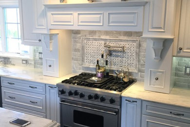 Inspiration for a large transitional l-shaped dark wood floor and brown floor eat-in kitchen remodel in New York with a farmhouse sink, raised-panel cabinets, white cabinets, granite countertops, gray backsplash, subway tile backsplash, stainless steel appliances and an island