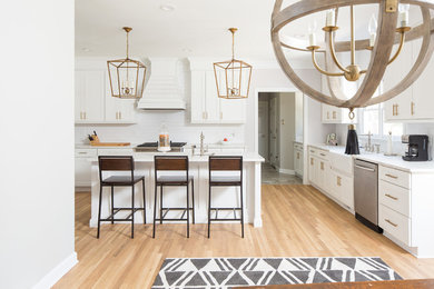 Inspiration for a mid-sized contemporary u-shaped light wood floor eat-in kitchen remodel in Atlanta with a farmhouse sink, recessed-panel cabinets, white cabinets, quartz countertops, white backsplash, ceramic backsplash, stainless steel appliances, an island and white countertops