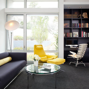 デンバーの大きいモダンスタイルのおしゃれなホームオフィス・仕事部屋 (白い壁、カーペット敷き、暖炉なし、造り付け机、黒い床) の写真