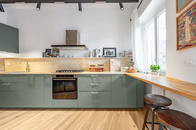 Immagine di una cucina minimal con ante lisce, paraspruzzi beige, parquet chiaro e parquet e piastrelle