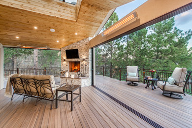Transitional backyard deck photo in Denver with a fire pit and a roof extension