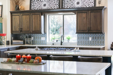 Example of a huge transitional u-shaped ceramic tile, beige floor and exposed beam open concept kitchen design in Albuquerque with an undermount sink, raised-panel cabinets, dark wood cabinets, quartz countertops, blue backsplash, ceramic backsplash, stainless steel appliances, two islands and white countertops