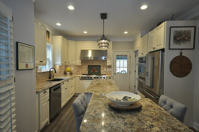 Mid-sized minimalist u-shaped brown floor eat-in kitchen photo in Atlanta with white cabinets, granite countertops, stainless steel appliances and an island
